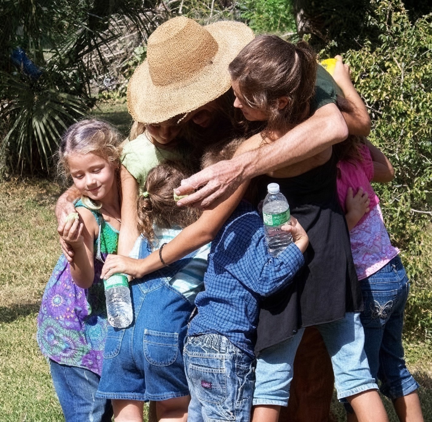 Children giving Farmer Sal a group hug on the farm